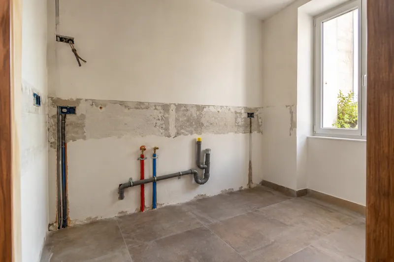Visualización conceptual IA: Tuberías de suministro y desagüe durante la renovación de una cocina.